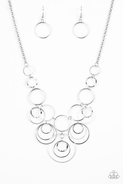 Break The Cycle - Silver Item #N728 Featuring smooth and delicately hammered finishes, mismatched silver hoops connect below the collar for a bold industrial look. Features an adjustable clasp closure. All Paparazzi Accessories are lead free and nickel free!  Sold as one individual necklace. Includes one pair of matching earrings.