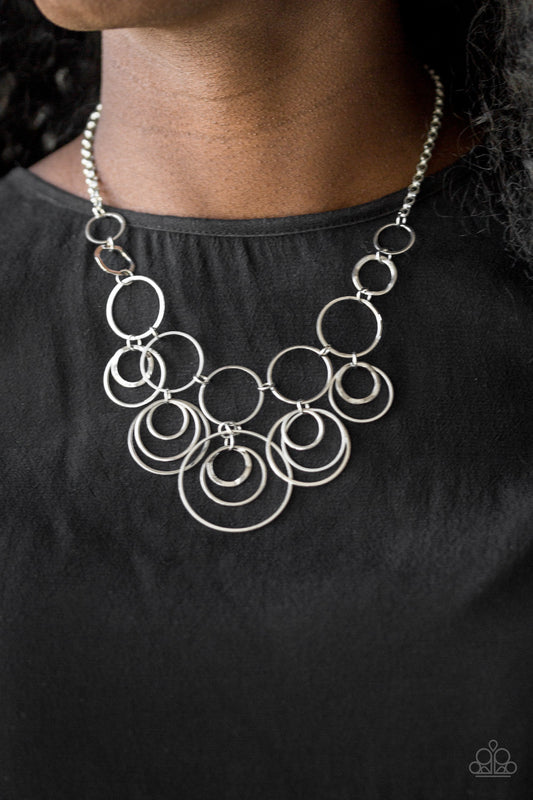 Break The Cycle - Silver Item #N728 Featuring smooth and delicately hammered finishes, mismatched silver hoops connect below the collar for a bold industrial look. Features an adjustable clasp closure. All Paparazzi Accessories are lead free and nickel free!  Sold as one individual necklace. Includes one pair of matching earrings.