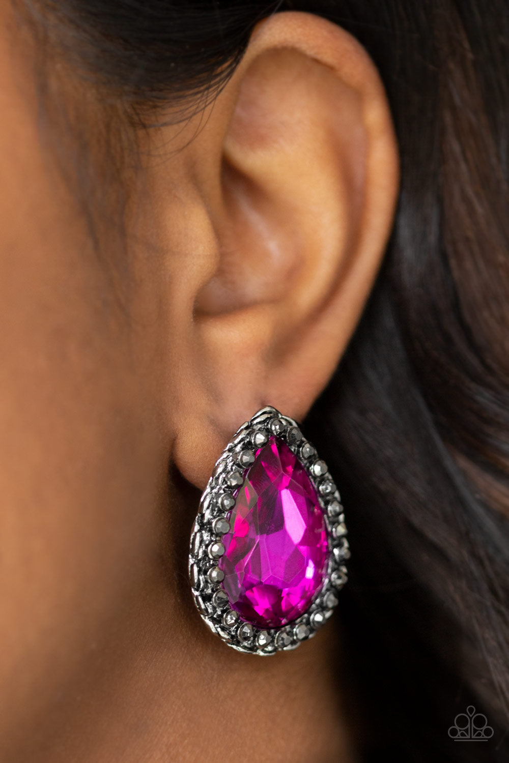 Dare To Shine - Pink Item #E427 Encrusted in a ring of glittery hematite rhinestones, an overly dramatic pink teardrop gem is pressed into a textured silver frame for a grunge-glamorous look. Earring attaches to a standard post fitting. All Paparazzi Accessories are lead free and nickel free!  Sold as one pair of post earrings.