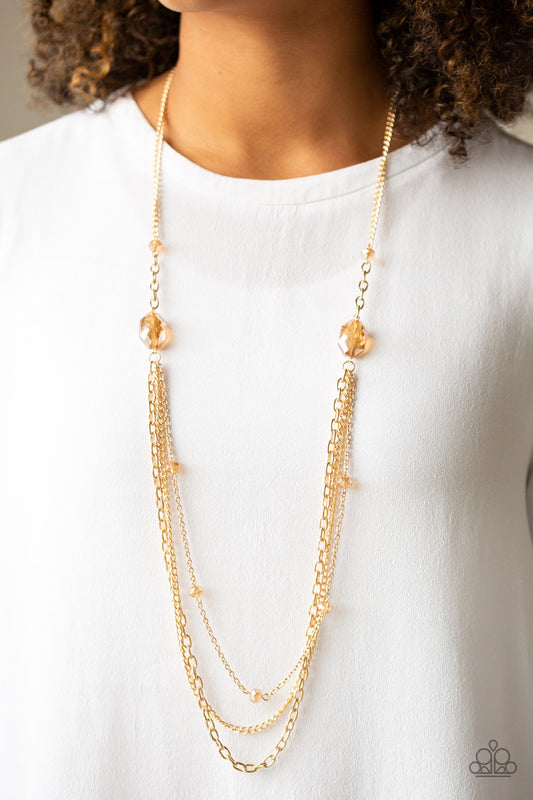 Dare To Dazzle - Gold Item #N635 Infused with golden crystal-like beads, a pair of golden gems gives way to layers of mismatched gold chains for a dazzling look. Features an adjustable clasp closure. All Paparazzi Accessories are lead free and nickel free!  Sold as one individual necklace. Includes one pair of matching earrings.