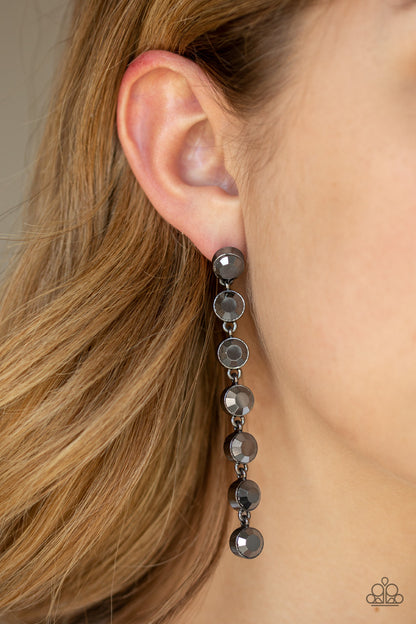Dazzling Debonair - Black Item #E402 Featuring sleek gunmetal fittings, a collection of oversized hematite rhinestones drip from the ear for a glamorous look. Earring attaches to a standard post fitting. All Paparazzi Accessories are lead free and nickel free!  Sold as one pair of post earrings.