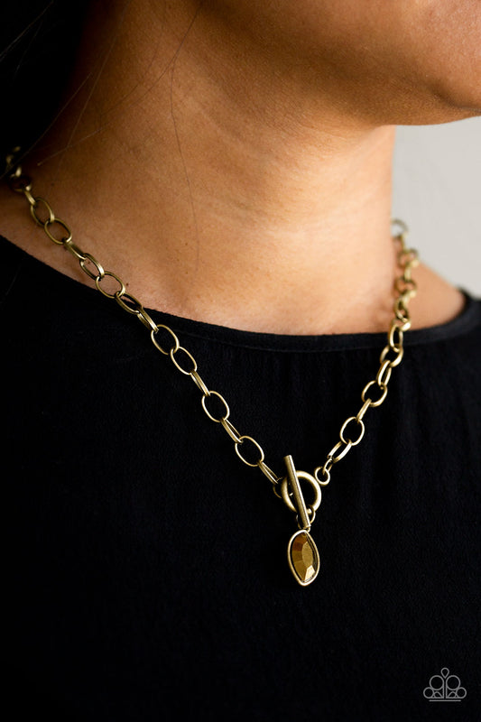 Club Sparkle Brass Necklace - Paparazzi Accessories  Featuring a regal marquise style cut, a glittery aurum rhinestone swings from the bottom of a brass chain below the collar for a classic look. Features a toggle closure.  All Paparazzi Accessories are lead free and nickel free!  Sold as one individual necklace. Includes one pair of matching earrings.