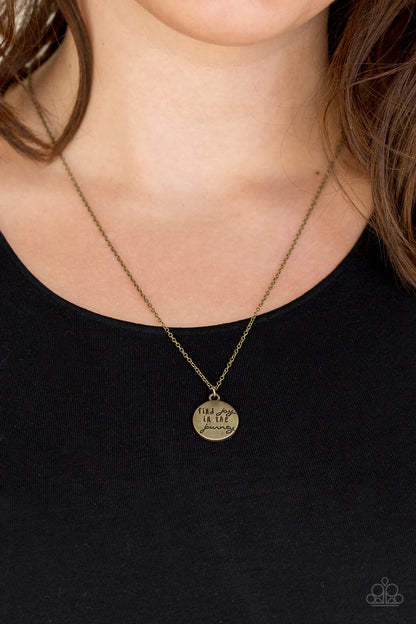 Find Joy Brass Necklace - Paparazzi Accessories  Stamped in the inspirational phrase, "find joy in the journey," a round brass pendant swings below the collar for a seasonal look. Features an adjustable clasp closure.  All Paparazzi Accessories are lead free and nickel free!  Sold as one individual necklace. Includes one pair of matching earrings.