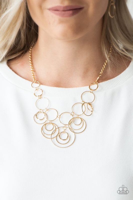 Break The Cycle Gold Necklace - Paparazzi Accessories.  Featuring smooth and delicately hammered finishes, mismatched gold hoops connect below the collar for a bold industrial look. Features an adjustable clasp closure.  All Paparazzi Accessories are lead free and nickel free!  Sold as one individual necklace. Includes one pair of matching earrings.