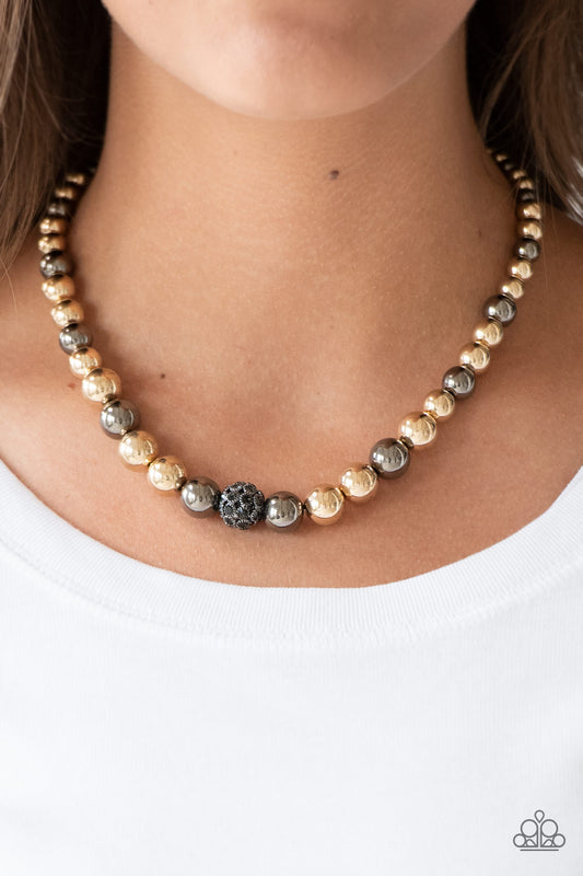 High-Stakes FAME Multi Necklace - Paparazzi Accessories  Gradually increasing in size near the center, glistening gold and gunmetal beads are threaded along an invisible wire below the collar. Encrusted in smoky rhinestones, a sparkling gunmetal bead adorns the center for a refined finish. Features an adjustable clasp closure.  Sold as one individual necklace. Includes one pair of matching earrings.