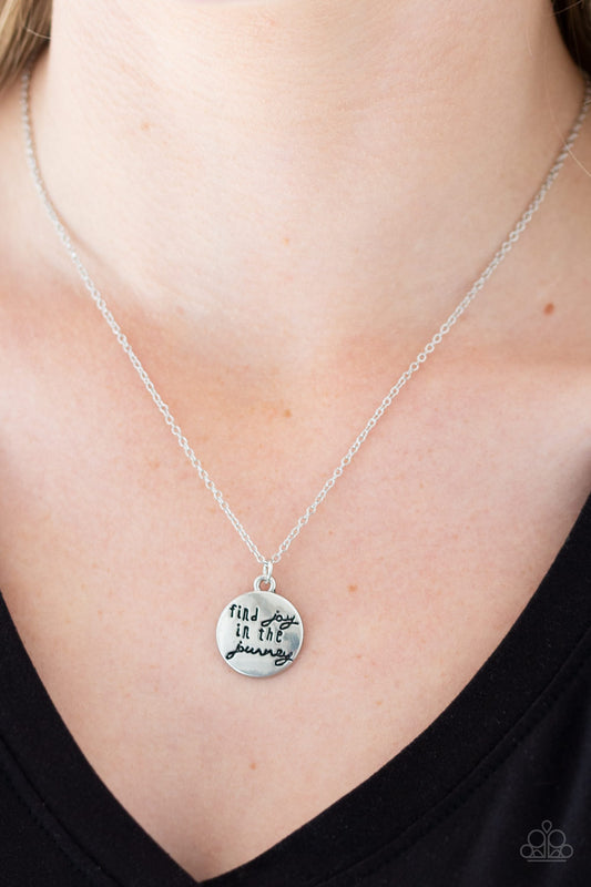 Find Joy Silver Necklace - Paparazzi Accessories  Stamped in the inspirational phrase, "find joy in the journey," a round silver pendant swings below the collar for a seasonal look. Features an adjustable clasp closure.  All Paparazzi Accessories are lead free and nickel free!  Sold as one individual necklace. Includes one pair of matching earrings.