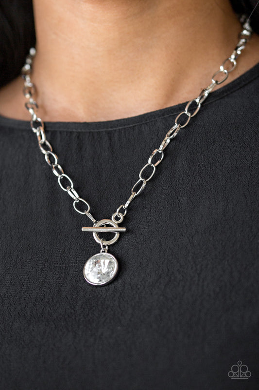 She Sparkles On White Toggle Necklace - Paparazzi Accessories  A dramatic gem white swings from the bottom of a shiny silver chain, creating a blinding pendant below the collar. Features a toggle closure.  ﻿All Paparazzi Accessories are lead free and nickel free!  Sold as one individual necklace. Includes one pair of matching earrings.  Get The Complete Look!  Bracelet: "All Aglitter - White" (Sold Separately)