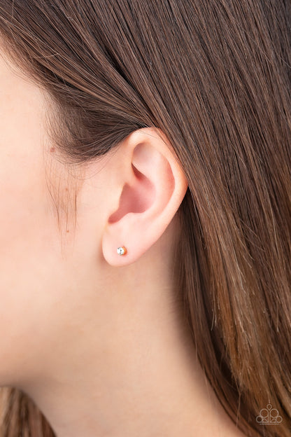 Dainty Decor - Gold Item #E267 A dainty white cubic zirconia is pressed into the center of a sleek gold frame for a timeless look. Earring attaches to a standard post fitting. Features a daintier design to accommodate multiple ear piercings. All Paparazzi Accessories are lead free and nickel free!  Sold as one pair of post earrings.