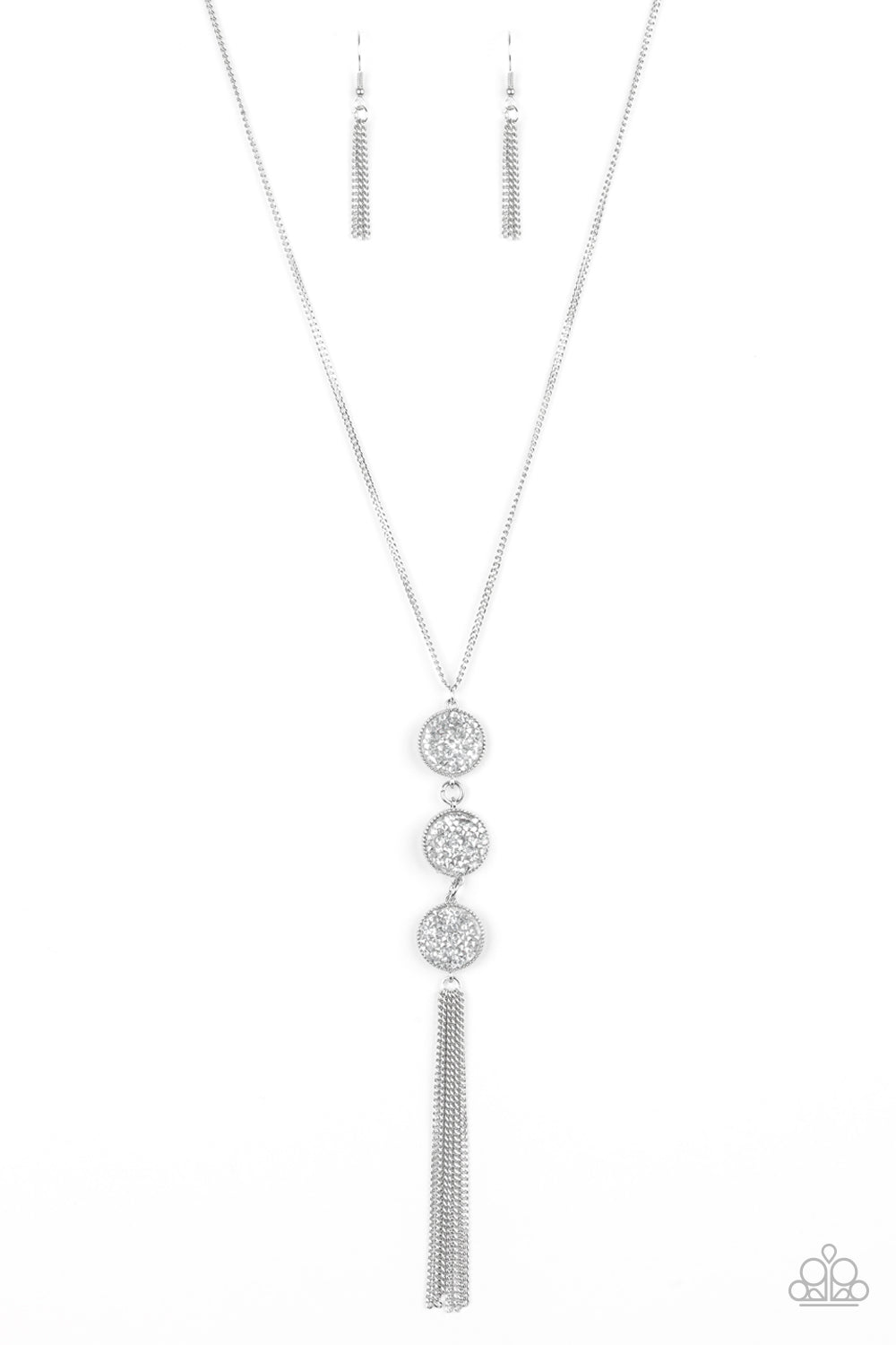 Triple Shimmer White Necklace - Paparazzi Accessories  Sprinkled in glassy white and smoky hematite prism style rhinestones, three sparkling silver frames trickle down the chest. A shimmery silver tassel swings from the bottom of the triple stacked pendant for a glamorous finish. Features an adjustable clasp closure.   Sold as one individual necklace. Includes one pair of matching earrings.