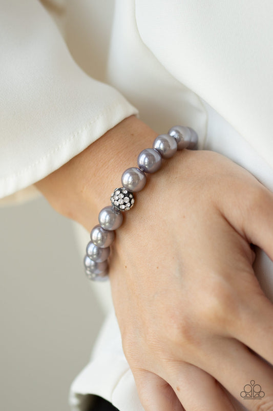 POSHing Your Luck Silver Bracelet - Paparazzi Accessories. Infused with a glittery rhinestone encrusted bead, a collection of silver pearls are threaded along a stretchy band around the wrist for a glamorous look.  All Paparazzi Accessories are lead free and nickel free!  Sold as one individual bracelet.  Get The Complete Look! Necklace: "Posh Boss - Silver" (Sold Separately)