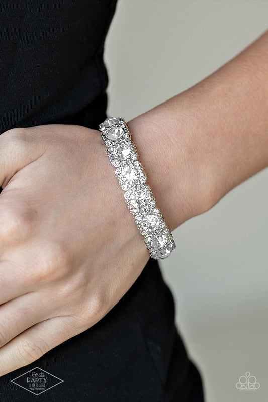 Blinged Out White Bracelet - Paparazzi Accessories  Featuring oversized white rhinestone centers, studded silver frames radiating in glassy white rhinestones are threaded along a stretchy band around the wrist for a glamorous fashion.  Sold as one individual bracelet. This Fan Favorite is back in the spotlight at the request of our 2021 Life of the Party member with Black Diamond Access, Leigh B.