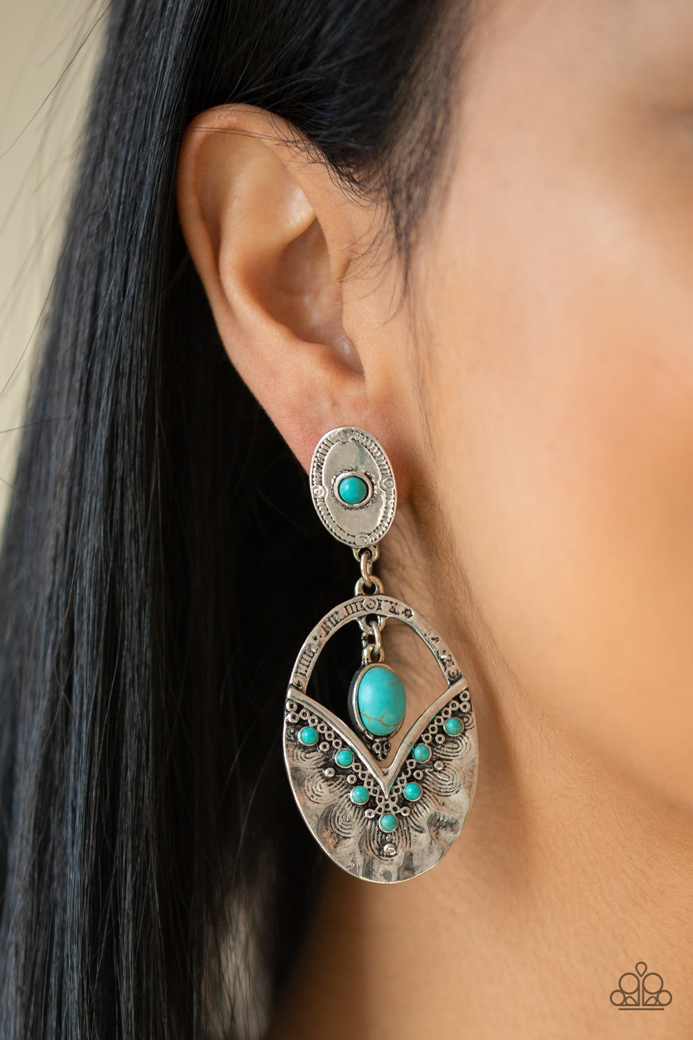 Terra Tribute Blue Earring - Paparazzi Accessories  Rippling with hammered silver textures, a turquoise stone dotted frame swings from the bottom of an ornate oval frame dotted with a matching turquoise stone. A smooth turquoise stone swings from the top of the ornate frame, creating an earthy lure. Earring attaches to a standard post fitting.   All Paparazzi Accessories are lead free and nickel free!  Sold as one pair of post earrings.