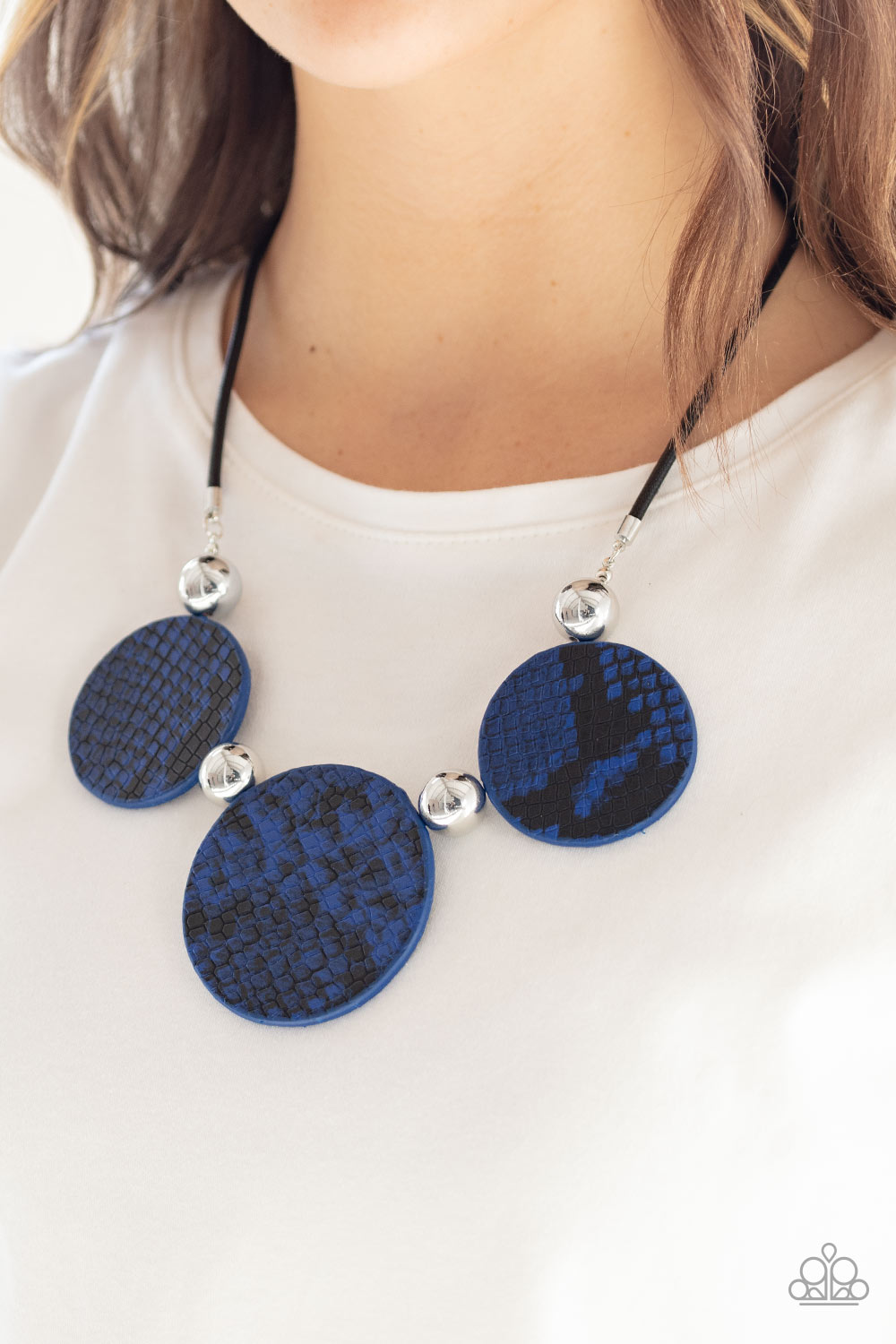 Viper Pit Blue Necklace - Paparazzi Accessories  A wild collection of oversized silver beads and blue and black python patterned leather pieces are strung along an invisible wire below the collar for a statement-making finish. Features an adjustable clasp closure.  Sold as one individual necklace. Includes one pair of matching earrings.