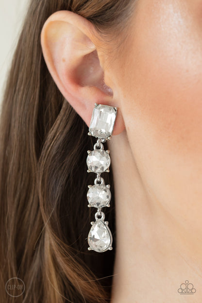 Make A-LIST White Earring - Paparazzi Accessories  Featuring a glassy white finish, a collection of emerald, round, and teardrop cut rhinestones drip from the ear, connecting into a glamorous lure. Earring attaches to a standard clip-on fitting.   All Paparazzi Accessories are lead free and nickel free!  Sold as one pair of clip-on earrings.