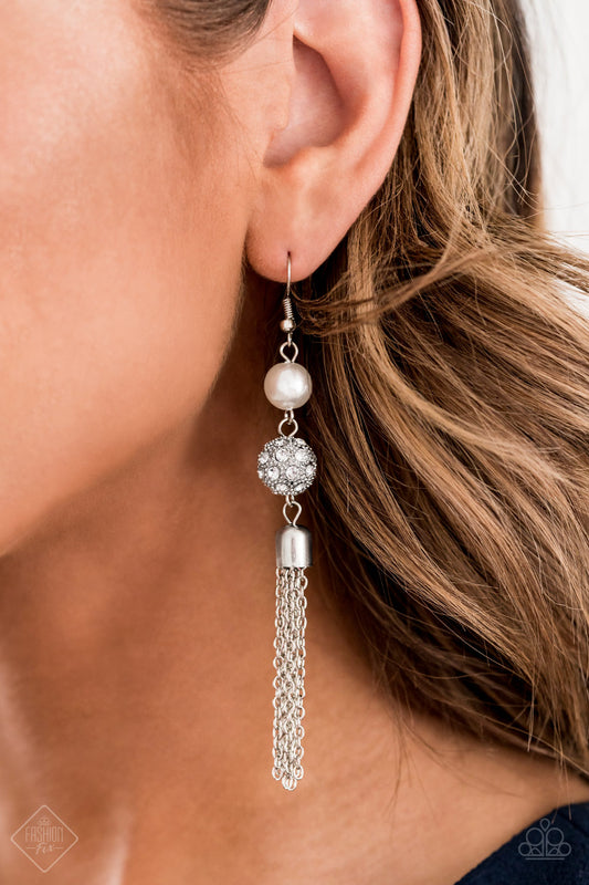 Going DIOR to DIOR White Pearl Earring - Paparazzi Accessories  A solitaire white pearl gives way to a glittery white rhinestone-encrusted silver bead. A shimmery silver tassel cascades from the bottom of the stacked elegance for a flirty finish. Earring attaches to a standard fishhook fitting.  Sold as one pair of earrings.