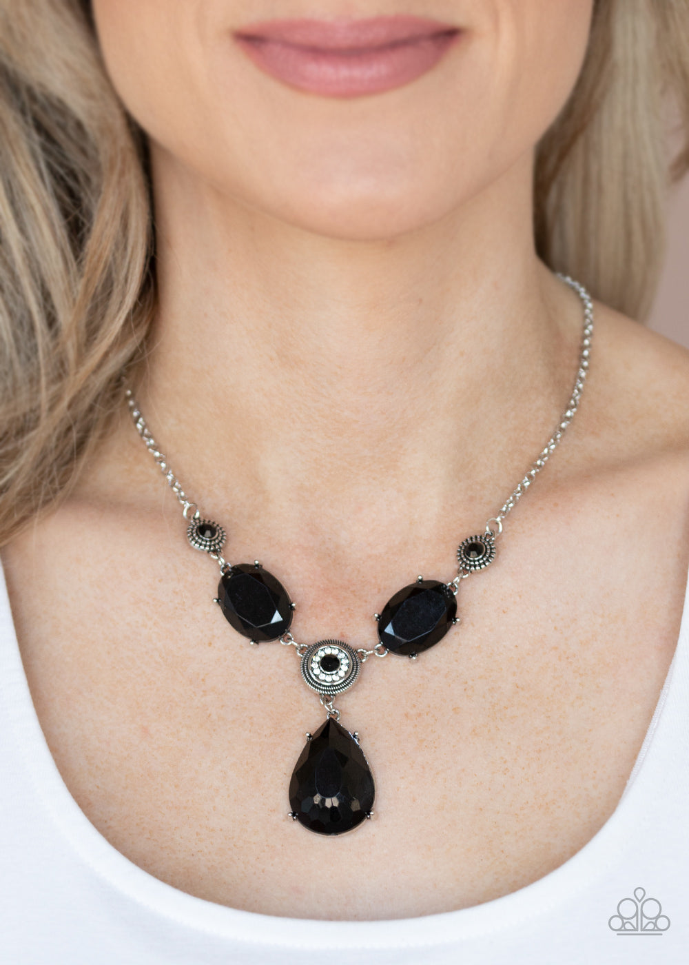 Heirloom Hideaway Black Necklace - Paparazzi Accessories. A collection of black and white rhinestone dotted silver frames link with a pair of black oval gems below the collar. A dramatically oversized black teardrop drips from the center, creating a glamorous pendant. Features an adjustable clasp closure.  All Paparazzi Accessories are lead free and nickel free!   Sold as one individual necklace. Includes one pair of matching earrings.