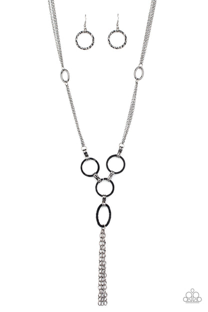 Metro Mechanics Black Necklace - Paparazzi Accessories. Hammered gunmetal rings and ovals link into an industrial style pendant at the bottom of shimmery sections of gunmetal chains. Classic gunmetal chains stream from the bottom of the display, adding edgy movement. Features an adjustable clasp closure.  All Paparazzi Accessories are lead free and nickel free!  Sold as one individual necklace. Includes one pair of matching earrings.