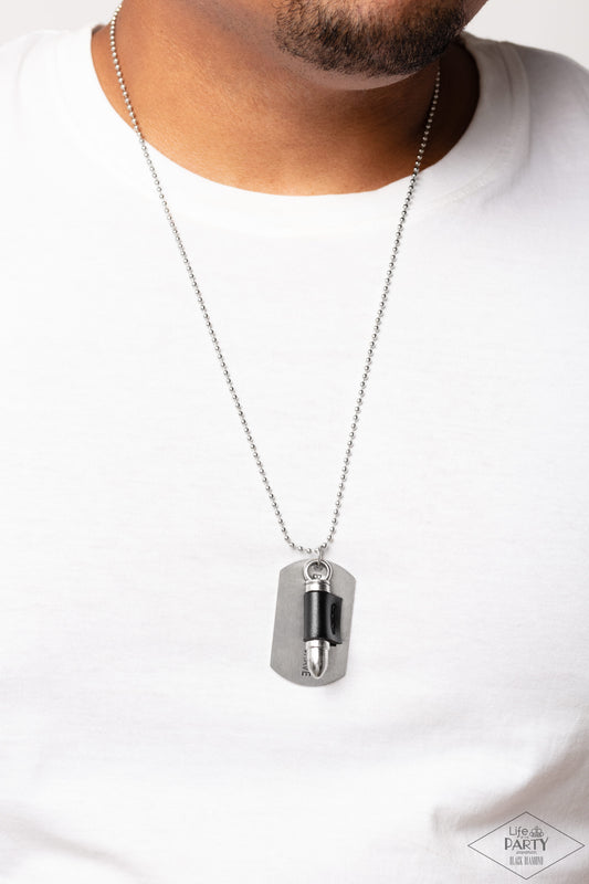 Proud Patriot Black Necklace - Paparazzi Accessories  Pinched between a black leather fitting, a silver bullet pendant joins a silver dog tag at the bottom of a silver ball chain. The shimmery dog tag is stamped in the phrase, "Because of the Brave," for a patriotic finish. Features a ball and clasp closure.  Sold as one individual necklace.  P2MN-URBK-057XX