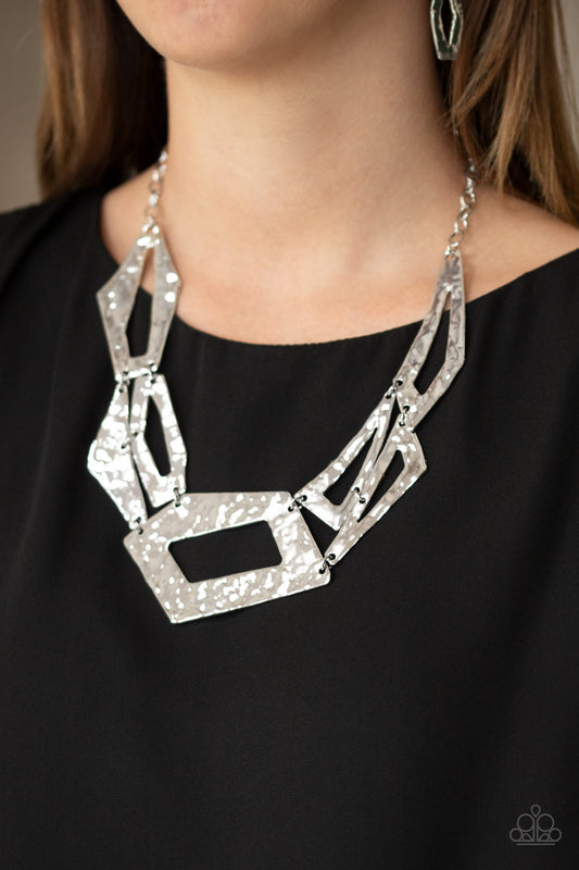 Break The Mold Silver Necklace - Paparazzi Accessories  Attached to an edgy silver chain, hammered silver plates featuring asymmetrical shapes abstractly link below the collar for a knockout look. Features an adjustable clasp closure.  All Paparazzi Accessories are lead free and nickel free!  Sold as one individual necklace. Includes one pair of matching earrings.