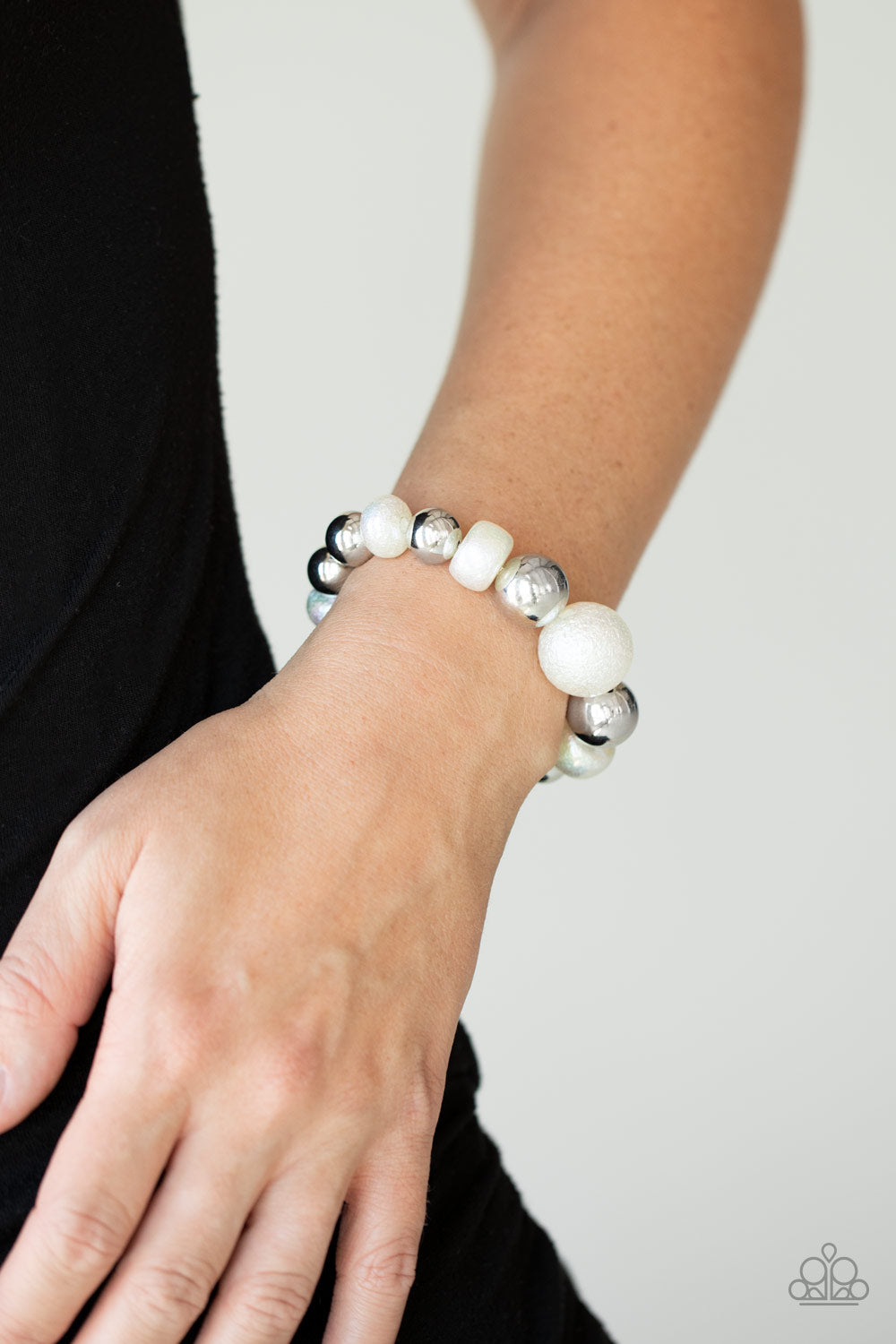 Starstruck Shimmer White Bracelet- Paparazzi Accessories.  Brushed in a stellar iridescence, hammered pearly beads and classic silver beads gradually increase in size as they slide along a stretchy band around the wrist for a glamorous look. All Paparazzi Accessories are lead free and nickel free!  Sold as one individual bracelet.  Get The Complete Look! Necklace: "Twinkle Twinkle, I'm The Star - White" (Sold Separately)