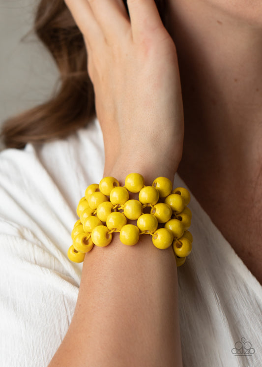 Tiki Tropicana Yellow Wooden Bracelet - Paparazzi Accessories. An oversized collection of sunny yellow wooden beads are threaded along stretchy bands that ornately weave across the wrist, creating a decorative summery pattern.  All Paparazzi Accessories are lead free and nickel free!  Sold as one individual bracelet.