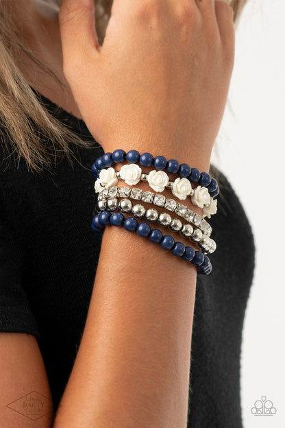 Rose Garden Grandeur Blue Bracelet - Paparazzi Accessories  A vintage inspired collection of ivory resin roses, navy beads, and classic silver beads join a stretchy band of glittery white rhinestones dotted around the wrist for a flawlessly stacked look.  Sold as one set of five bracelets. This Fan Favorite is back in the spotlight at the request of our 2021 Life of the Party member with Black Diamond Access, Andrea H.