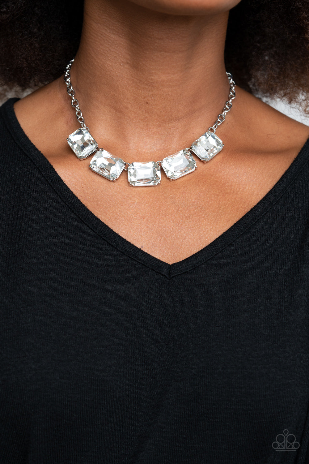 Deep Freeze Diva White Necklace - Paparazzi Accessories  Featuring regal emerald style cuts, an oversized collection of white rhinestones dramatically link below the collar for an icy finish. Features an adjustable clasp closure. All Paparazzi Accessories are lead free and nickel free!  Sold as one individual necklace. Includes one pair of matching earrings.