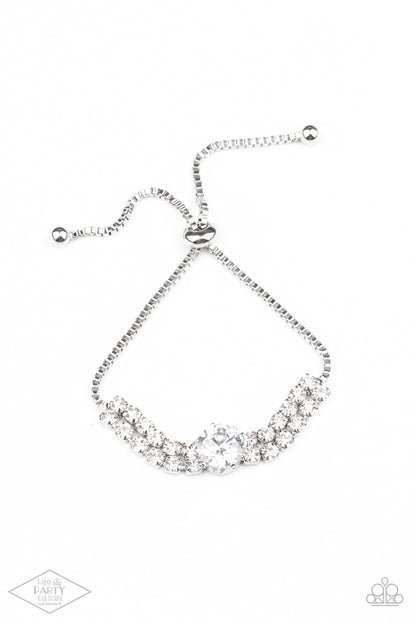 Gorgeously Glitzy White Bracelet - Paparazzi Accessories  An oversized white rhinestone dots the center of two rows of glittery white rhinestones that attach to a dainty strand of silver box chain around the wrist for a glamorous finish. Features an adjustable sliding bead closure.  Sold as one individual bracelet. This Fan Favorite is back in the spotlight at the request of our 2021 Life of the Party member with Black Diamond Access, Courtney V.