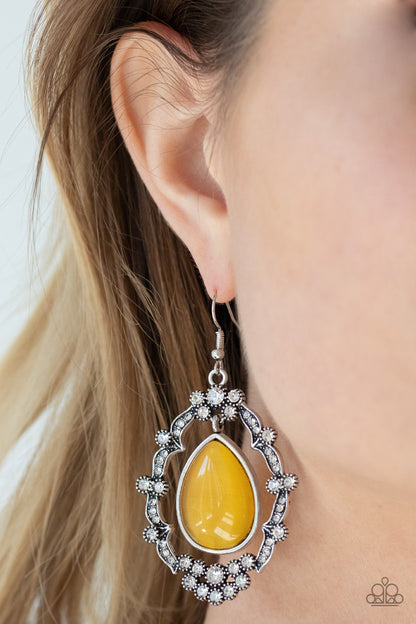 Icy Eden Yellow Earring - Paparazzi Accessories. A teardrop yellow cat's eye stone swings from the top of an ornately white rhinestone encrusted frame, creating an icy lure. Earring attaches to a standard fishhook fitting.  ﻿All Paparazzi Accessories are lead free and nickel free!  Sold as one pair of earrings. 