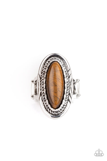 Primal Instincts Brown Ring - Paparazzi Accessories  An oblong tiger's eye stone is pressed into the center of an oval silver frame stamped and embossed in mismatched patterns for a seasonal flair. Features a stretchy band for a flexible fit.  ﻿All Paparazzi Accessories are lead free and nickel free!  Sold as one individual ring.