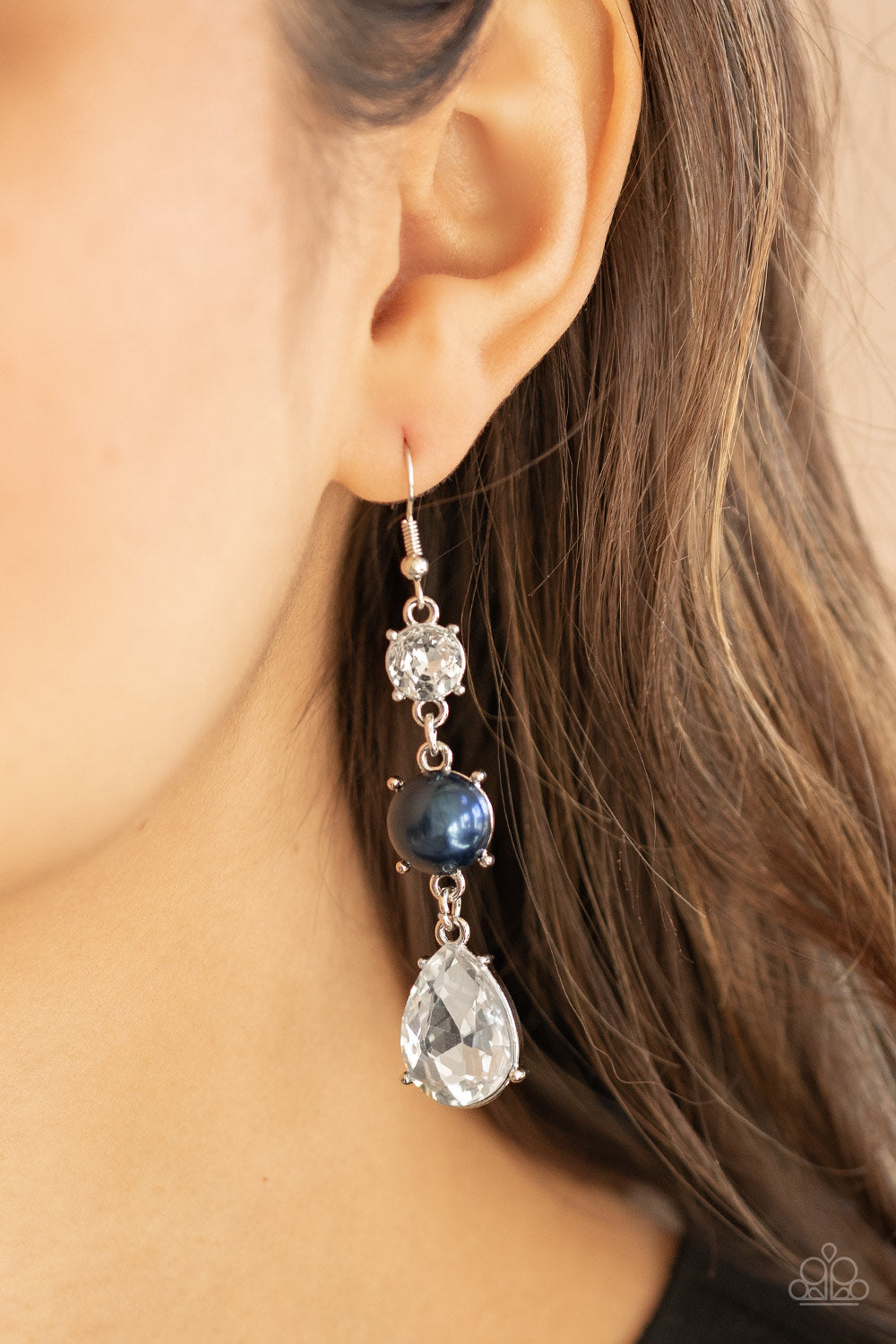 Unpredictable Shimmer Blue Earring - Paparazzi Accessories An oversized white teardrop gem swings from the bottom of a stacked pearly blue bead and classic white rhinestone, creating a timeless lure. Earring attaches to a standard fishhook fitting. ﻿All Paparazzi Accessories are lead free and nickel free! Sold as one pair of earrings.