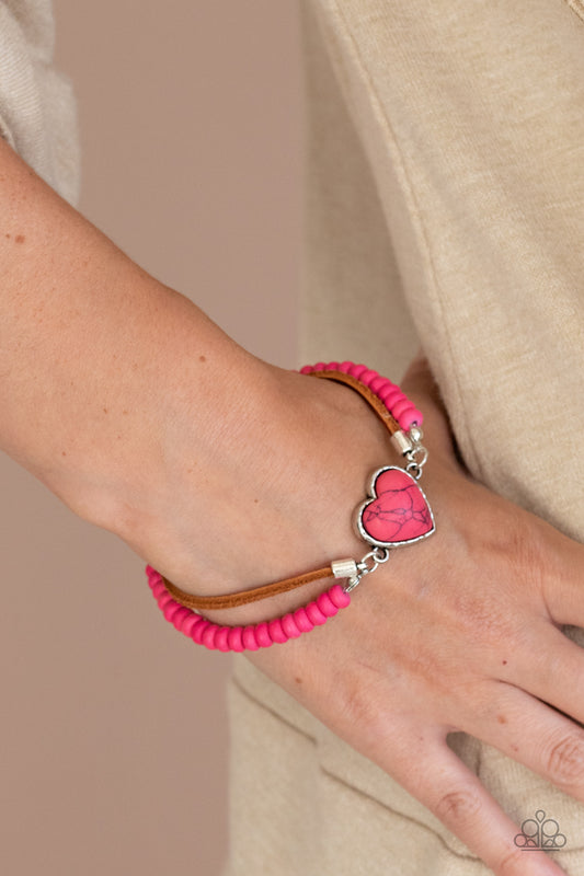 Charmingly Country Pink Heart Bracelet - Paparazzi Accessories  A vivacious pink stone heart frame attaches to strands of brown suede and pink stone beads, creating a charming centerpiece around the wrist. Features an adjustable clasp closure.  Sold as one individual bracelet.  Get The Complete Look! Necklace: "Country Sweetheart - Pink" (Sold Separately)