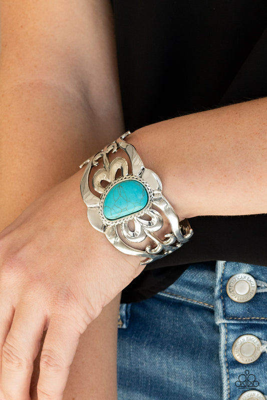 The MESAS are Calling Blue Cuff Bracelet - Paparazzi Accessories  An asymmetrical turquoise stone is pressed into the center of a silver cuff layered with filigree patterns around the wrist for a rustic flair.  ﻿All Paparazzi Accessories are lead free and nickel free!  Sold as one individual bracelet.