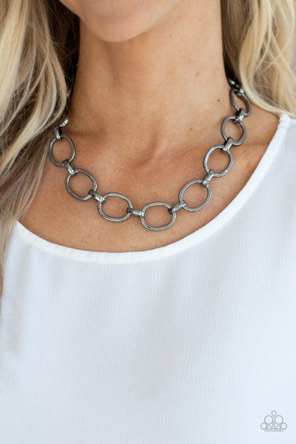 HAUTE-ly Contested Black Necklace - Paparazzi Accessories  A glistening series of dramatically oversized ovals and links boldly connect below the collar, creating an intense industrial statement. Features an adjustable clasp closure.  All Paparazzi Accessories are lead free and nickel free!   Sold as one individual necklace. Includes one pair of matching earrings.