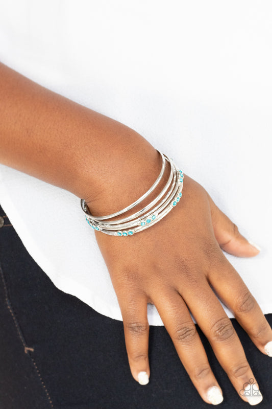 Stackable Sparkle Blue Bracelet - Paparazzi Accessories  Pairs of plain, textured, and blue rhinestone adorned silver bangles glide along the wrist for a sparkly look.  ﻿All Paparazzi Accessories are lead free and nickel free!  Sold as one set of six bracelets.