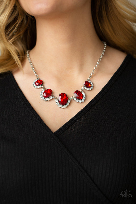 The Queen Demands It Red Necklace - Paparazzi Accessories. Gradually increasing in size at the center, the sparkly bottoms of oversized red gems are bordered in rows of glassy white rhinestones as they link below the collar for a dramatic effect. Features an adjustable clasp closure.  All Paparazzi Accessories are lead free and nickel free!  Sold as one individual necklace. Includes one pair of matching earrings.