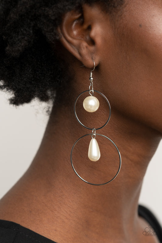 Cultured in Couture White Pearl Earring - Paparazzi Accessories  A classic white pearl swings from the top of a shiny silver hoop that is linked to another silver hoop by a pearly teardrop bead, creating a stunningly stacked display. Earring attaches to a standard fishhook fitting.  ﻿All Paparazzi Accessories are lead free and nickel free!  Sold as one pair of earrings.
