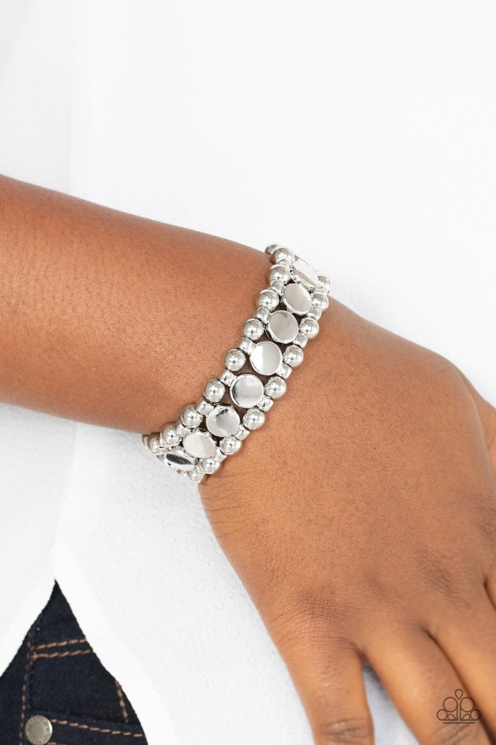 Metro Magnetism Silver Bracelet - Paparazzi Accessories  Shiny silver disc fittings and pairs of classic silver beads are threaded along stretchy bands around the wrist that connect into a bold industrial display around the wrist.  All Paparazzi Accessories are lead free and nickel free!  Sold as one individual bracelet.