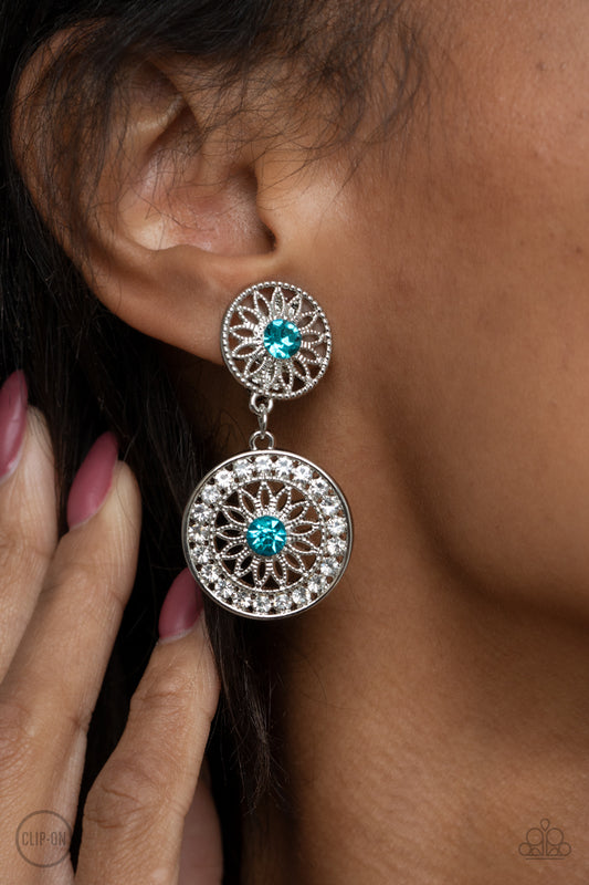 Life of The Garden Party Blue Clip-On Earring - Paparazzi Accessories.  Dotted with glittery blue rhinestone centers, shimmery silver floral frames link into a whimsical lure. The lower frame is bordered in glassy white rhinestones for a timeless finish. Earring attaches to a standard clip-on fitting.  ﻿All Paparazzi Accessories are lead free and nickel free!  Sold as one pair of clip-on earrings.
