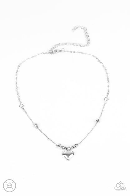 Casual Crush Silver Choker Necklace - Paparazzi Accessories  Infused with dainty silver beads, a charming silver heart dangles from a wire-like chain around the neck for a flirtatious look. Features an adjustable clasp closure.  Sold as one individual choker necklace. Includes one pair of matching earrings.