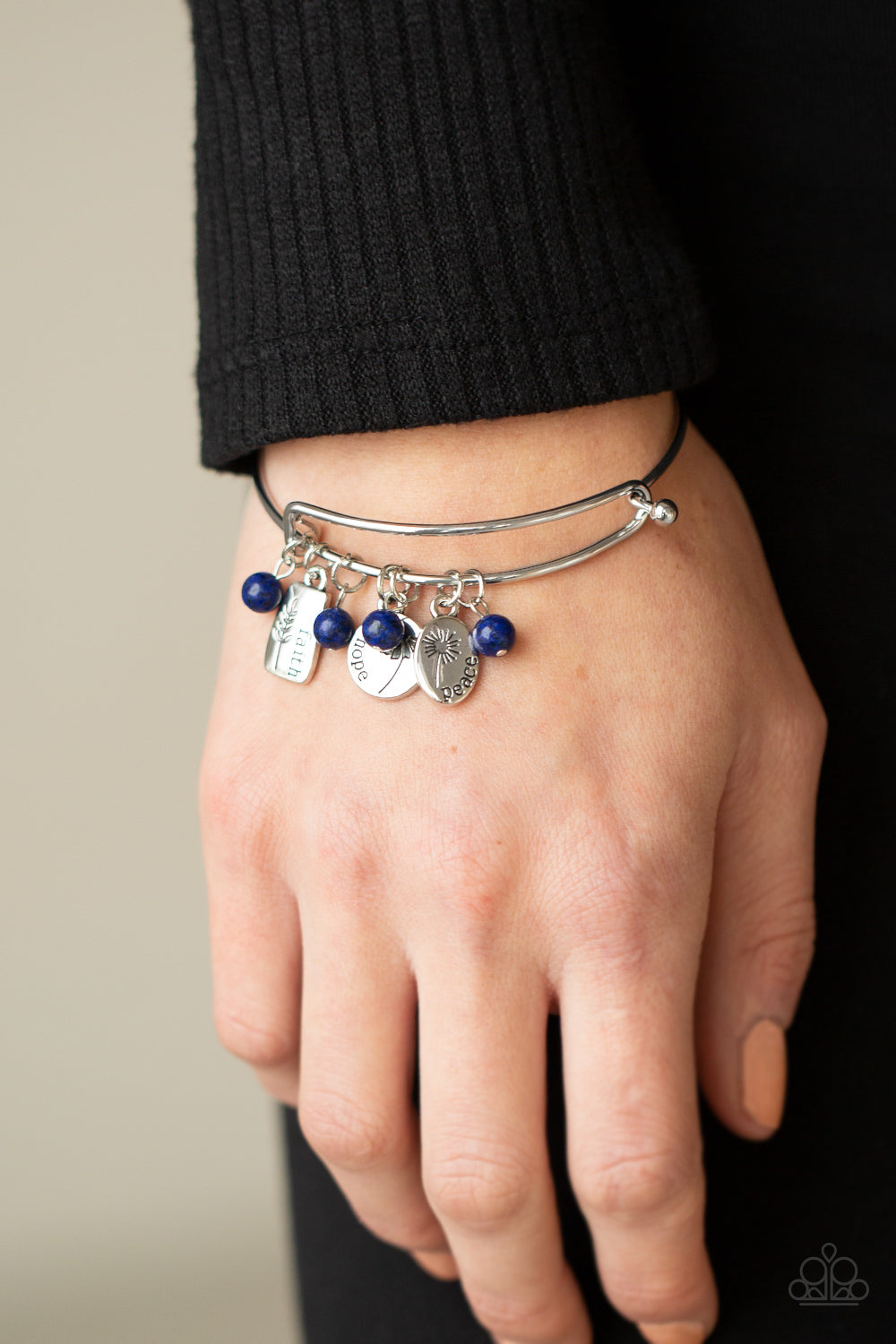 GROWING Strong Blue Inspirational Bracelet - Paparazzi Accessories  Glassy blue stone beads and silver floral charms stamped in the words, "faith," "hope," and "peace," glide along a dainty bangle-like cuff around the wrist for a whimsical flair. Features an adjustable toggle closure.  All Paparazzi Accessories are lead free and nickel free!  Sold as one individual bracelet.