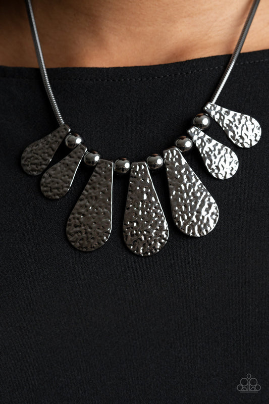 Gallery Goddess Black Necklace - Paparazzi Accessories.  Hammered teardrop-like frames and oversized gunmetal beads alternate along a round gunmetal herringbone chain, creating an intense industrial inspired fringe below the collar. Features an adjustable clasp closure.  ﻿All Paparazzi Accessories are lead free and nickel free!  Sold as one individual necklace. Includes one pair of matching earrings.