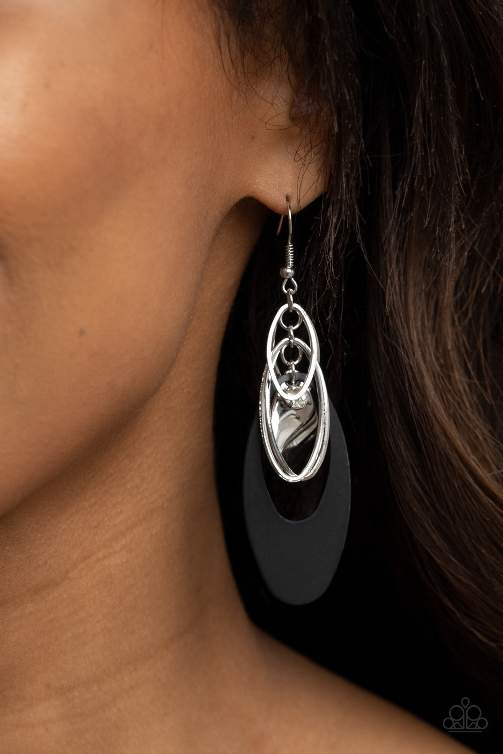 Ambitious Allure Black Earring - Paparazzi Accessories. Infused with a glassy white rhinestone, shiny silver ovals, a twisted silver plate, and an oversized black frame trickle along a shimmery silver chain, creating a noise-making tassel. Earring attaches to a standard fishhook fitting.  All Paparazzi Accessories are lead free and nickel free!  Sold as one pair of earrings.
