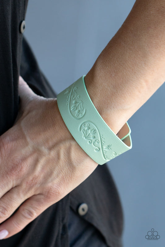 Butterfly Canopy Green Wrap Bracelet - Paparazzi Accessories. The front of a Green Ash leather band is stamped in a decorative butterfly and flower pattern, creating a whimsical display around the wrist. Features an adjustable snap closure.  ﻿All Paparazzi Accessories are lead free and nickel free!  Sold as one individual bracelet.
