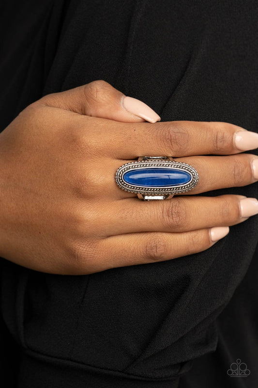 Stone Healer Blue Ring - Paparazzi Accessories  An oblong lapis lazuli stone is pressed into the center of a textured silver frame, dramatically dipping down the finger for a statement making stone fashion. Features a stretchy band for a flexible fit.  Sold as one individual ring.