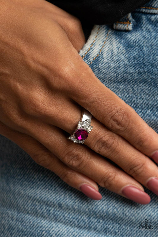 ROYAL Till The End Pink Ring - Paparazzi Accessories  Trios of glassy white rhinestones flank an oversized pink rhinestone, creating a sparkly centerpiece atop a dainty silver band. Features a dainty stretchy band for a flexible fit.  All Paparazzi Accessories are lead free and nickel free!  Sold as one individual ring.
