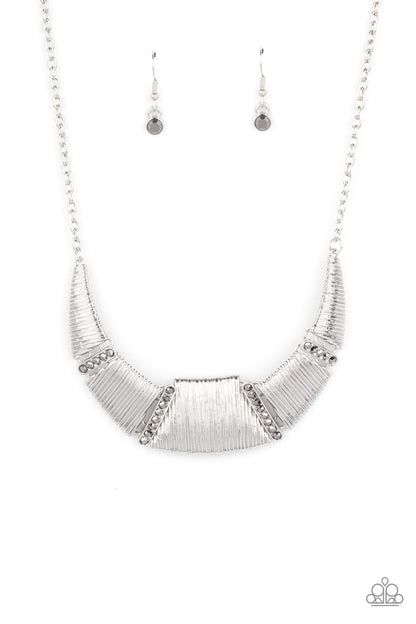 Going Through Phases Silver Necklace - Paparazzi Accessories  Embossed in linear textures, trapezoidal and triangular silver plates delicately link with dainty hematite rhinestone encrusted frames, creating a dramatic half moon below the collar. Features an adjustable clasp closure.  All Paparazzi Accessories are lead free and nickel free!  Sold as one individual necklace. Includes one pair of matching earrings.