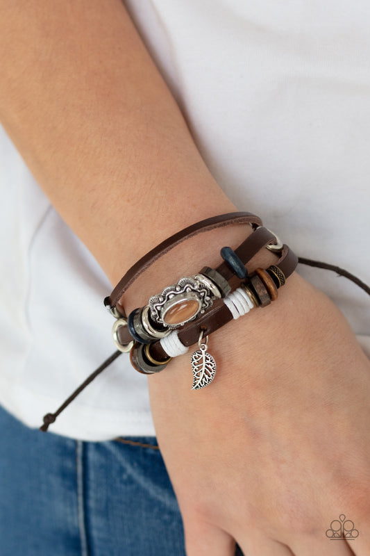 Mystically Mediterranean Orange Urban Bracelet - Paparazzi Accessories.  Infused with a scalloped orange cat's eye stone centerpiece, three layered leather bands are embellished with a mismatched collection of wooden and metallic rings for a seasonal finish. Features an adjustable sliding knot closure.  ﻿All Paparazzi Accessories are lead free and nickel free!  Sold as one individual bracelet.