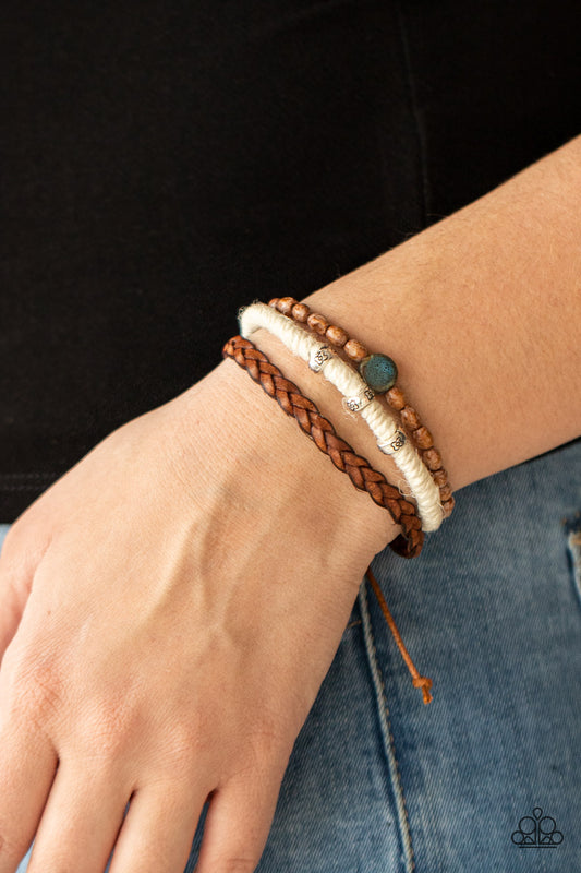 Terrarium Terrain Blue Urban Bracelet - Paparazzi Accessories  Featuring floral stamped accents and a colorful ceramic-like bead, strands of wooden beads, white twine, and braided leather layer around the wrist for an earthy look. Features an adjustable sliding knot closure.  All Paparazzi Accessories are lead free and nickel free!  Sold as one individual bracelet.