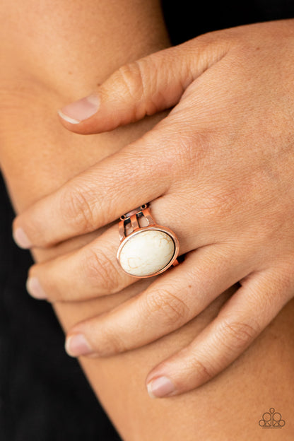 Divine Deserts Copper Ring - Paparazzi Accessories.  An oval white stone is nestled inside an antiqued copper frame that attaches to layered copper bands, creating a rustic stone centerpiece atop the finger. Features a stretchy band for a flexible fit.  ﻿﻿﻿All Paparazzi Accessories are lead free and nickel free!  Sold as one individual ring.